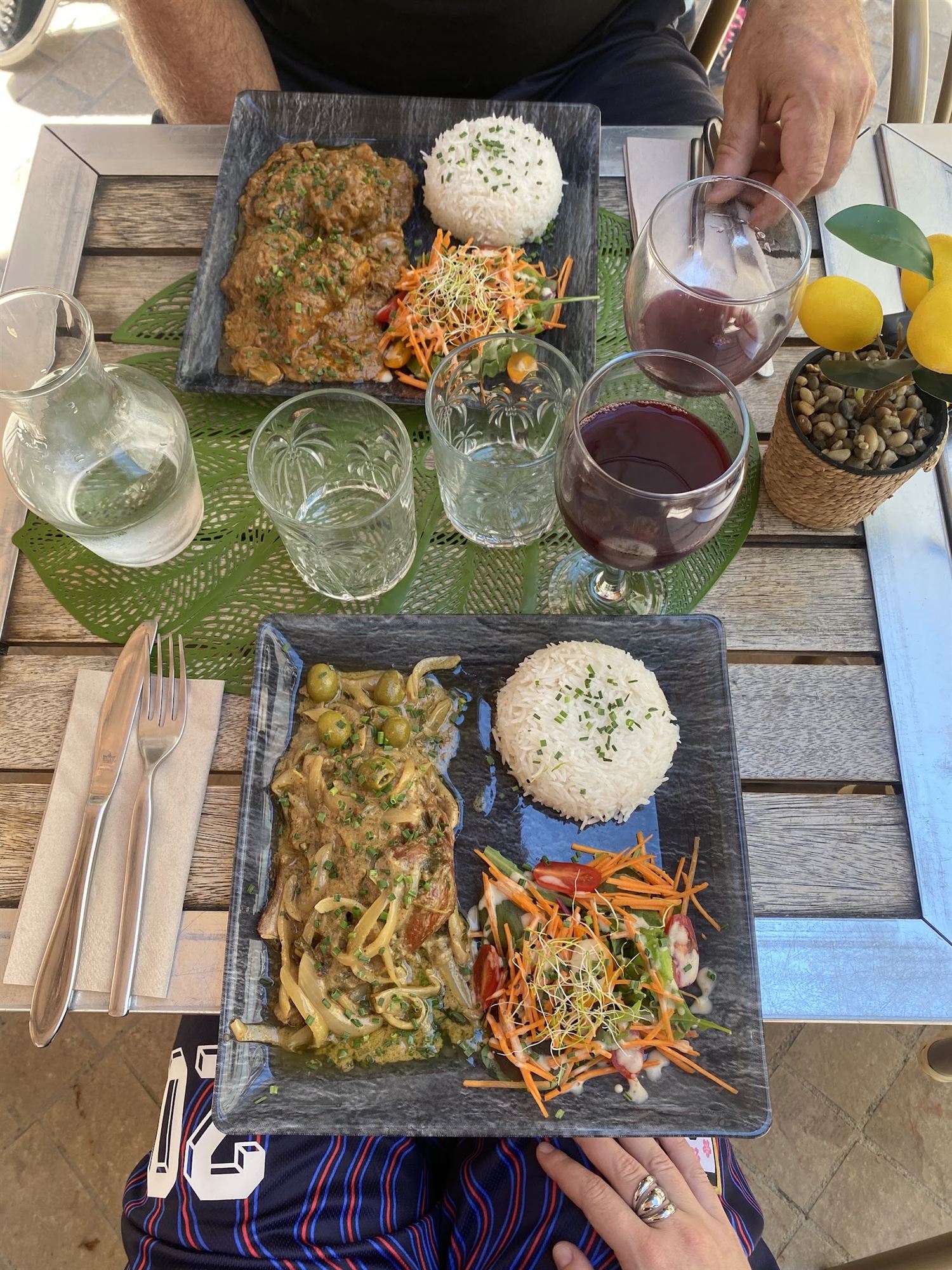 Un mafé de bœuf et un poulet yassa aux olives, riz blanc, salade, vus de dessus